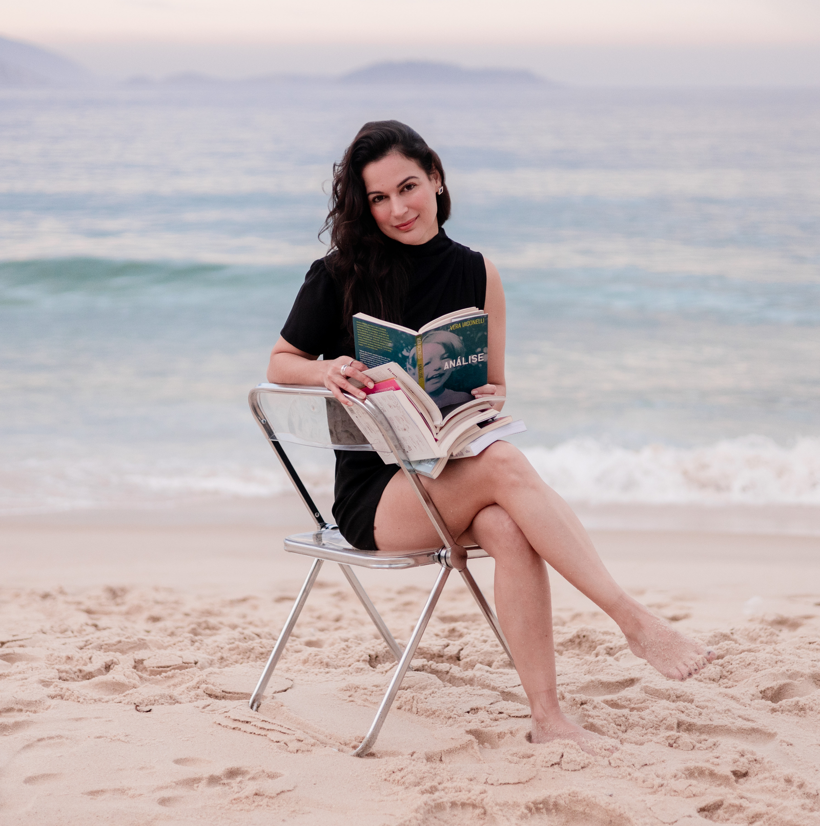 Karina Francis lendo um livro numa cadeira à beira-mar